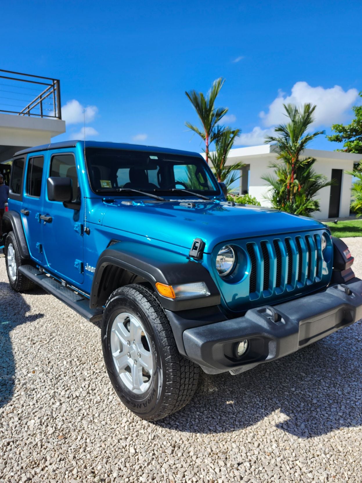 Blue Jeep glistening in the sun after being washed.